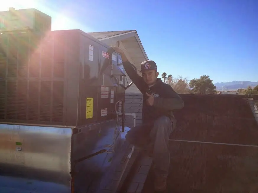 HVAC technician performing AC Tune-Up on a rooftop unit in Aldine